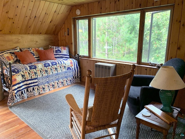 bedroom featuring multiple windows, light hardwood / wood-style floors, vaulted ceiling, wooden walls, and wood ceiling