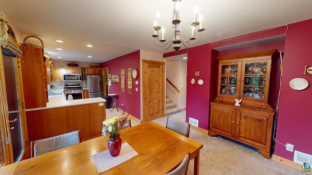 dining area with an inviting chandelier, sink, and light colored carpet