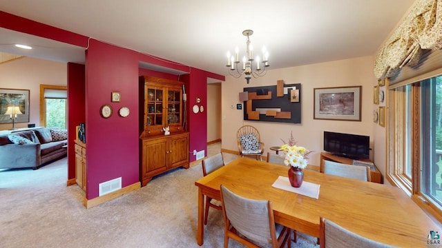 dining space featuring an inviting chandelier and light colored carpet