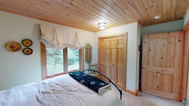 carpeted bedroom featuring a closet and wooden ceiling