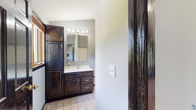 bathroom featuring tile patterned flooring, vaulted ceiling, and vanity