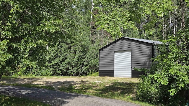 view of outbuilding with a view of trees and an outbuilding