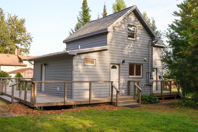 back of property featuring a yard and a deck