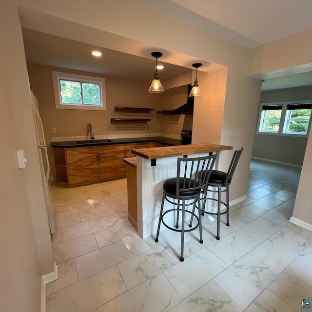 kitchen with light tile patterned floors, sink, and a breakfast bar