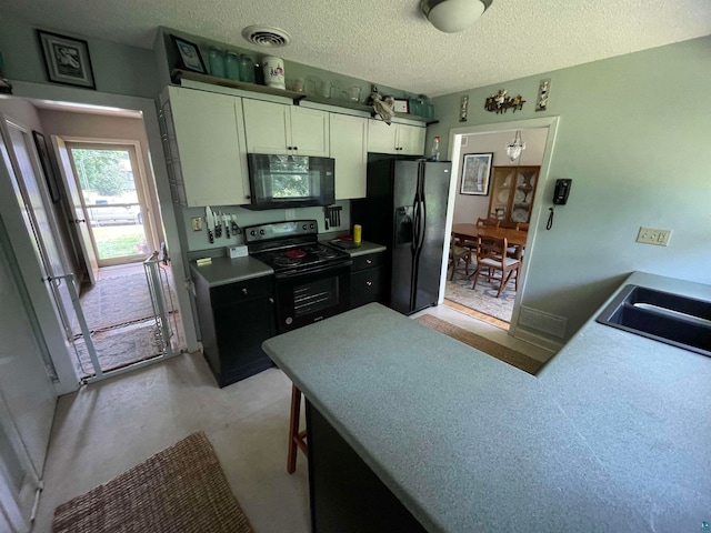 kitchen featuring white cabinets, sink, kitchen peninsula, a textured ceiling, and black appliances