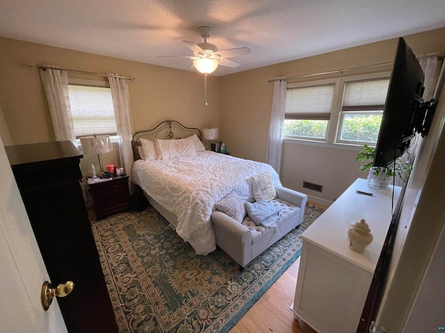 bedroom featuring a textured ceiling, ceiling fan, and hardwood / wood-style flooring