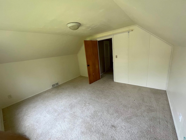 additional living space featuring light carpet and lofted ceiling