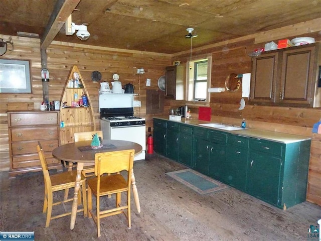 kitchen featuring wood walls, green cabinets, sink, and white range with gas cooktop