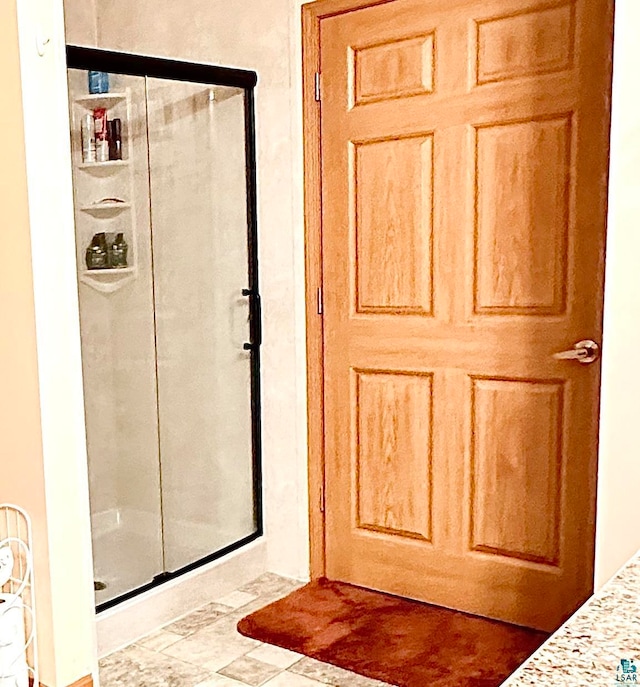 bathroom with an enclosed shower and tile patterned floors