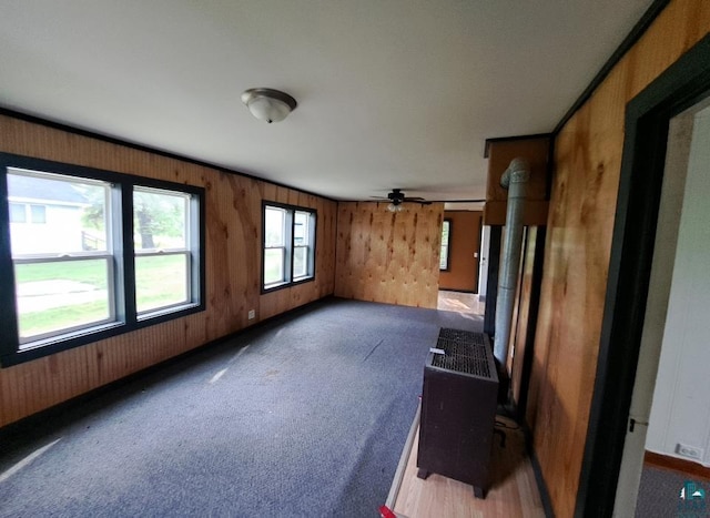 unfurnished living room featuring dark colored carpet and wooden walls