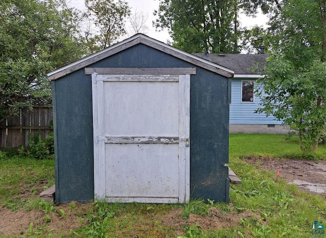 view of shed featuring fence