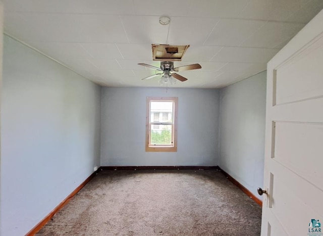 empty room featuring baseboards, dark carpet, and ceiling fan