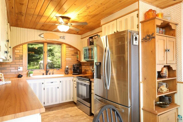 kitchen featuring stainless steel appliances, sink, light tile patterned floors, wood ceiling, and ceiling fan