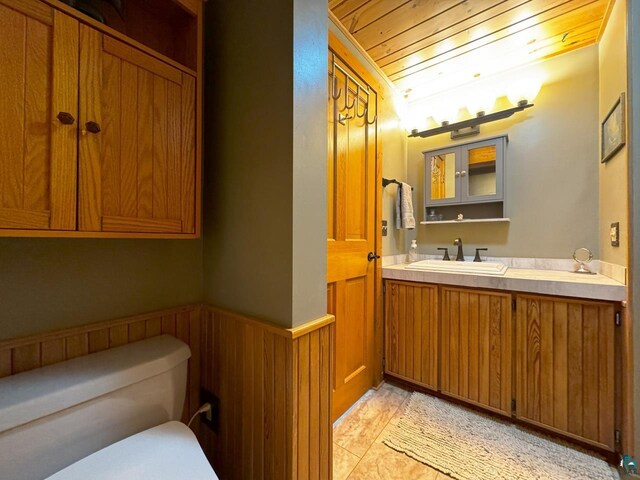 bathroom with toilet, wooden ceiling, vanity, and tile patterned floors