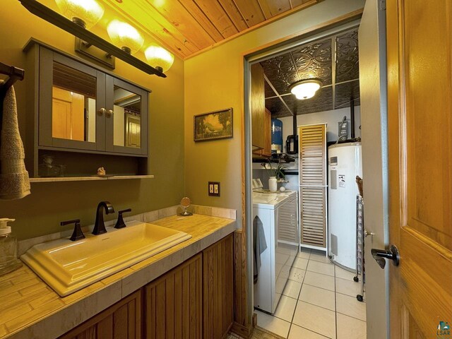 bathroom with washing machine and dryer, tile patterned flooring, vanity, wood ceiling, and electric water heater