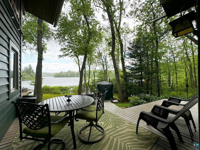 deck featuring outdoor dining space and a water view