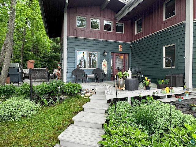 back of house with board and batten siding and a wooden deck