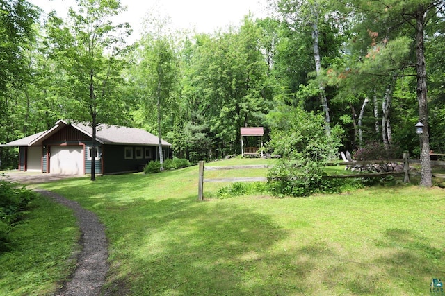 view of yard featuring a garage and an outbuilding