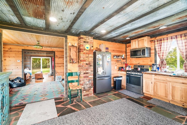 kitchen with wood walls, stainless steel appliances, brick wall, and light brown cabinetry