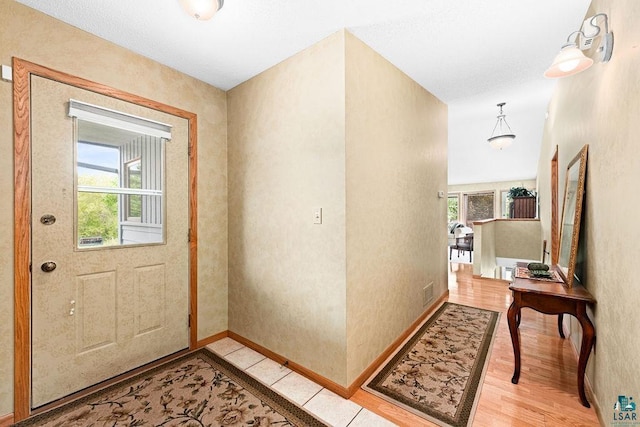 entryway with baseboards, visible vents, and light wood-style floors