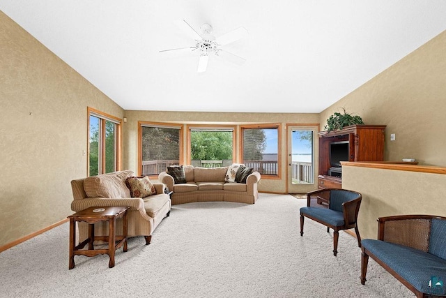 living room featuring light carpet, a textured wall, vaulted ceiling, and a ceiling fan