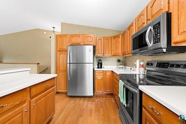 kitchen with appliances with stainless steel finishes, lofted ceiling, and light countertops