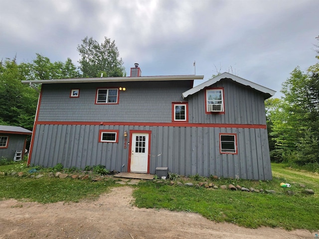 view of front of house with cooling unit and a front lawn