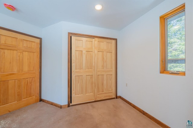 unfurnished bedroom featuring multiple windows, baseboards, and a closet