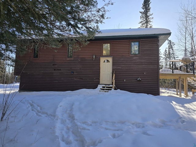 chalet / cabin with a deck, entry steps, and log veneer siding