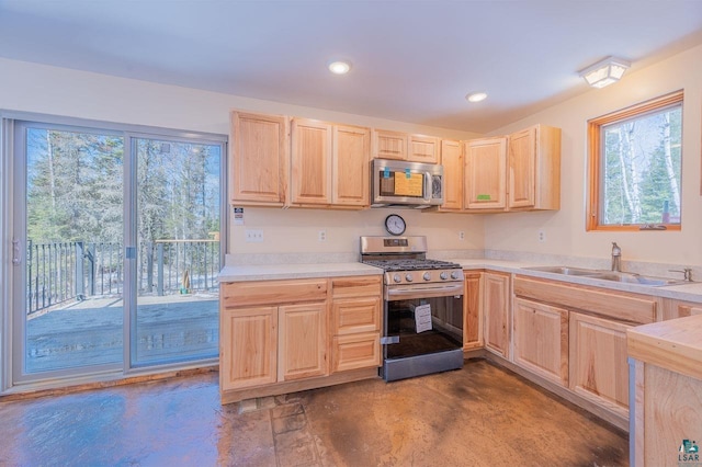 kitchen with light brown cabinetry, appliances with stainless steel finishes, finished concrete flooring, and a sink