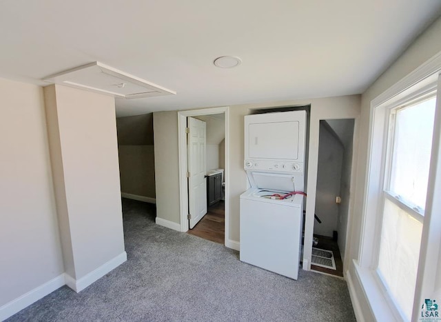 washroom featuring stacked washer / dryer and carpet flooring