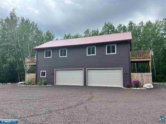 view of home's exterior with a garage, metal roof, and aphalt driveway