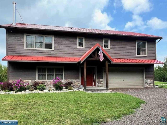 view of front of home featuring metal roof, an attached garage, stone siding, driveway, and a front yard