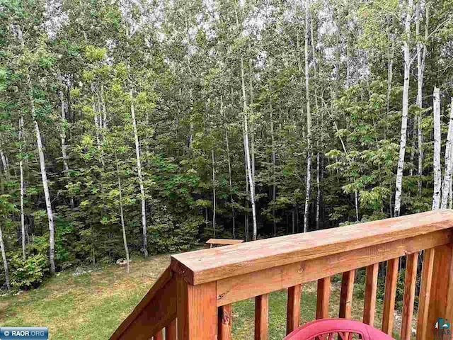 wooden terrace featuring a view of trees