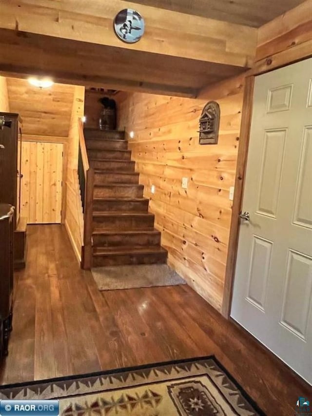 stairs with wood walls and wood finished floors