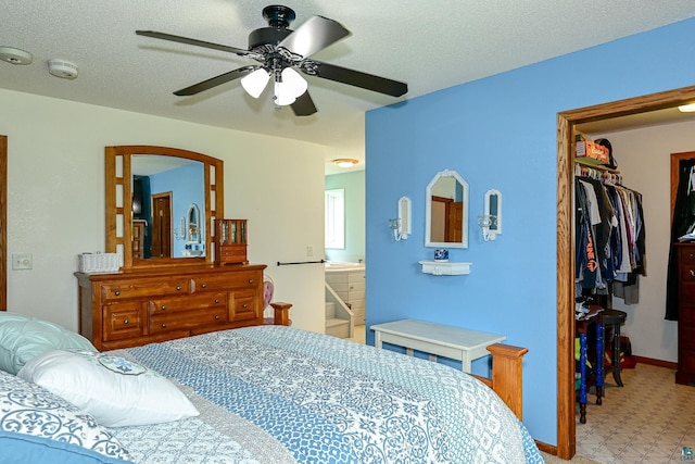 bedroom featuring a textured ceiling, ceiling fan, a closet, and a spacious closet