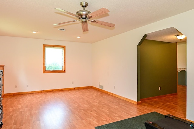 empty room with a textured ceiling, light hardwood / wood-style flooring, and ceiling fan