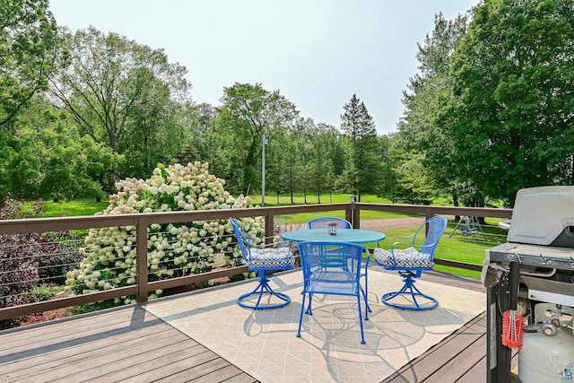 wooden terrace featuring grilling area and a lawn