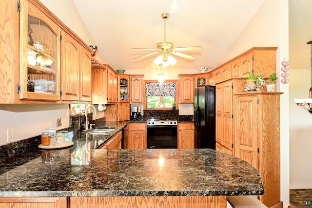 kitchen with range with electric cooktop, vaulted ceiling, kitchen peninsula, ceiling fan, and black fridge