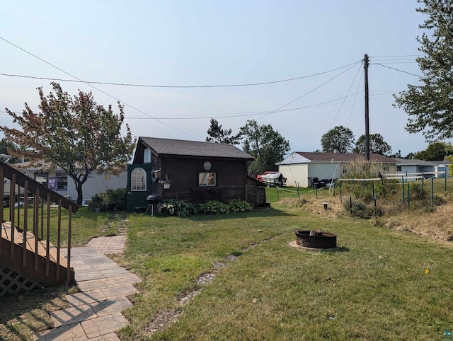 view of yard with a shed and an outdoor fire pit