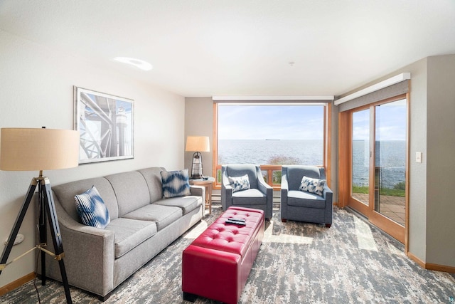 carpeted living room featuring a water view