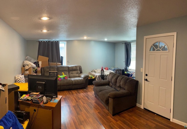 living room featuring a textured ceiling and dark hardwood / wood-style flooring