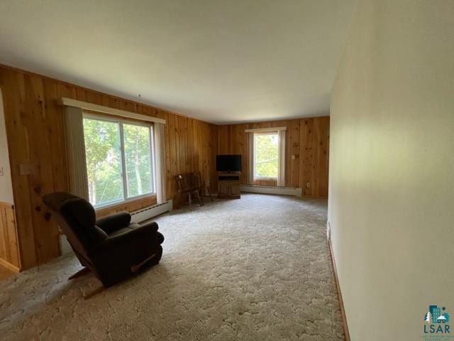 sitting room featuring baseboard heating and wood walls