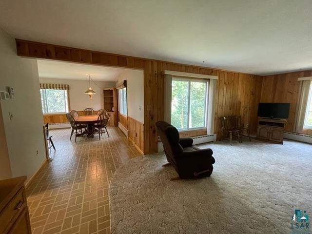 living room featuring a baseboard radiator and wood walls