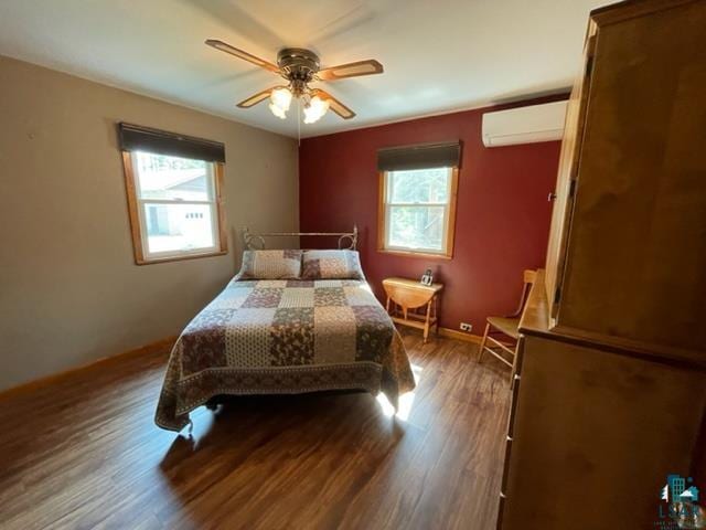 bedroom with dark wood-type flooring, ceiling fan, and a wall mounted air conditioner