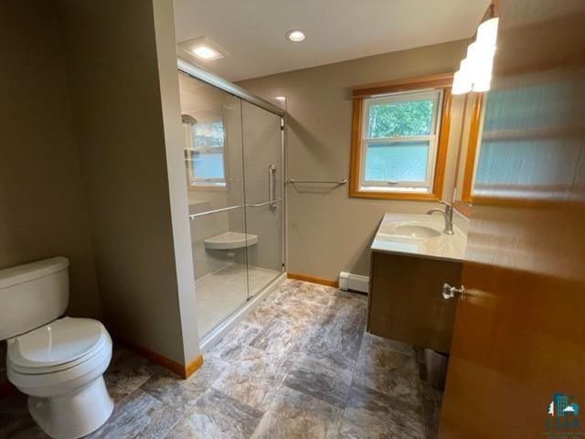 bathroom featuring vanity, toilet, baseboard heating, and walk in shower