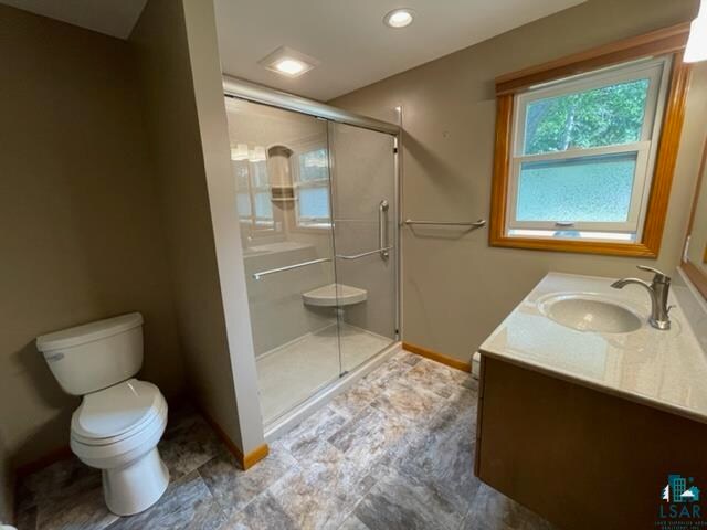 bathroom featuring vanity, toilet, and walk in shower