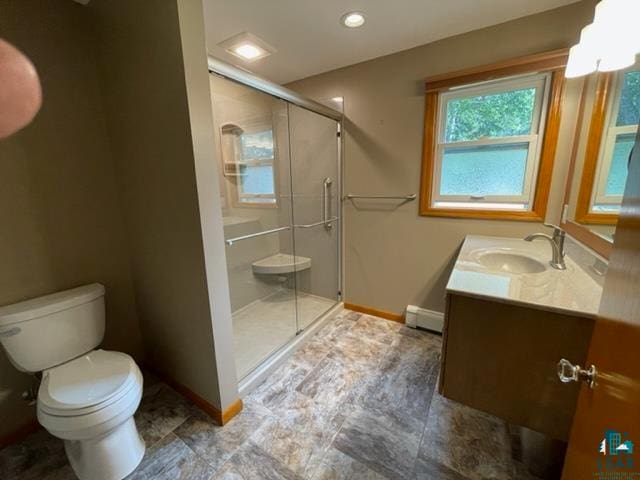 bathroom featuring a baseboard heating unit, toilet, a shower with door, and vanity