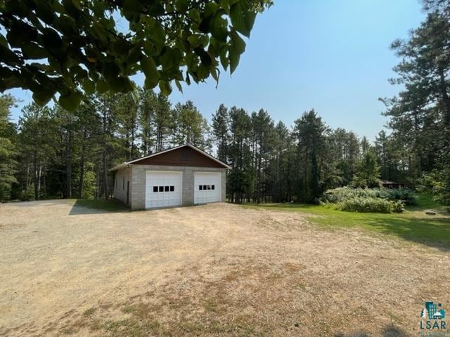 view of yard with a garage and an outbuilding