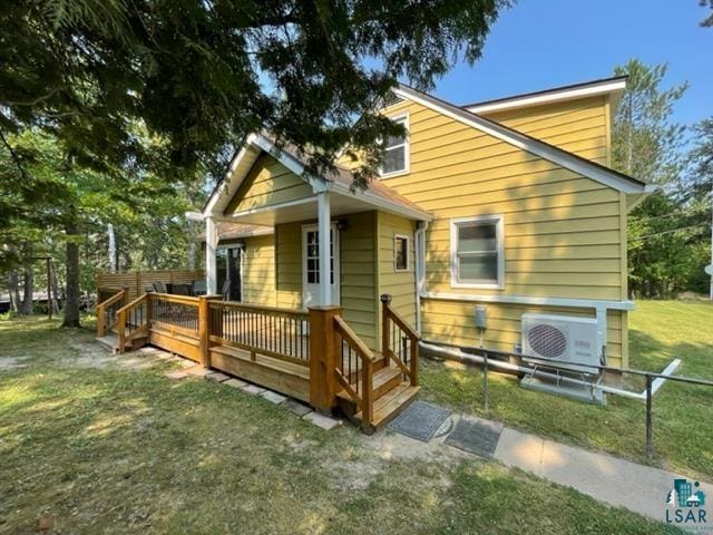 back of property featuring a yard, a wooden deck, and ac unit